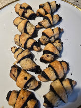 Load image into Gallery viewer, A plate of twelve Chocolate Rugelach, each a golden brown, crescent-shaped pastry with a rich chocolate filling visible in the spirals, arranged neatly in rows.